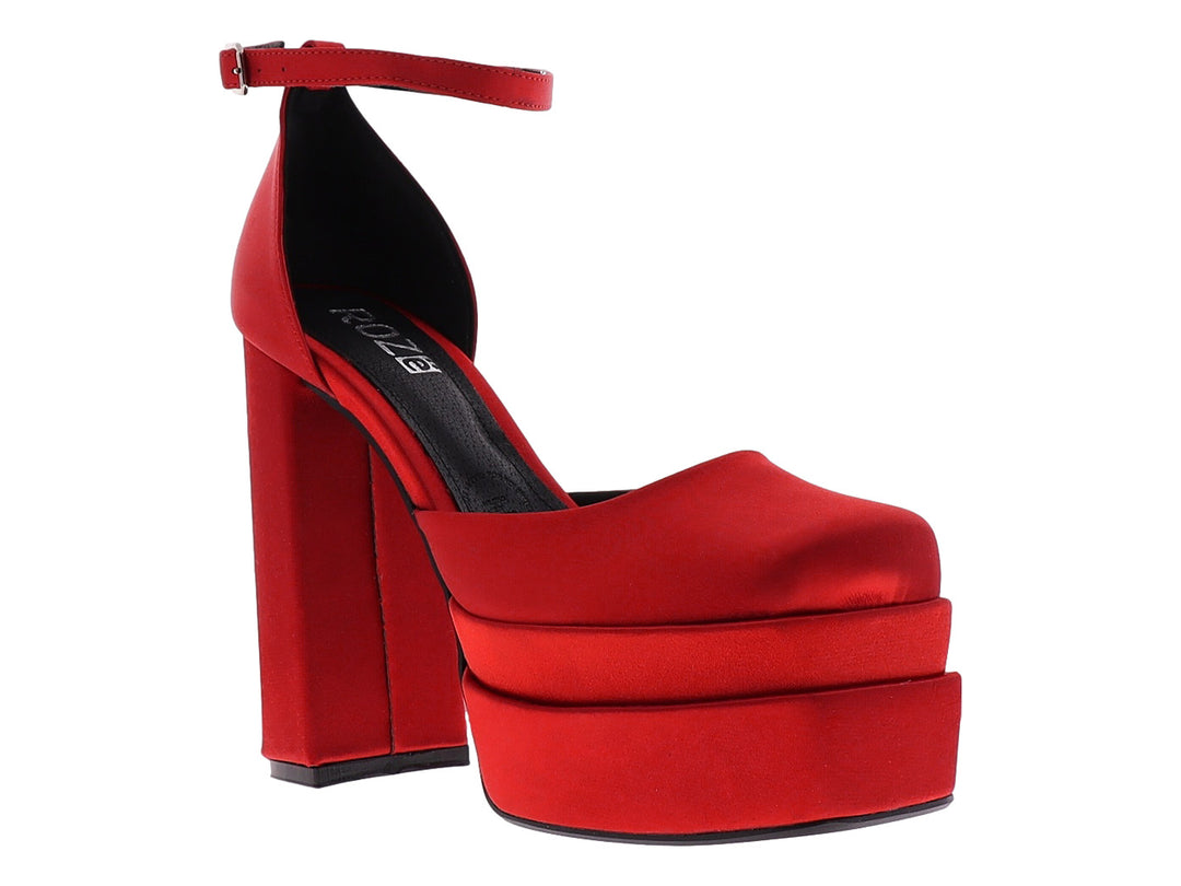 Zapato de tacón alto y plataforma en color rojo con acabado brillante y correa al tobillo.