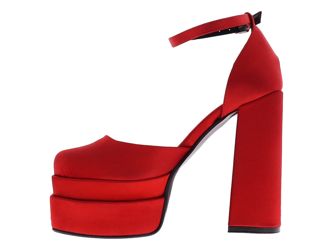 Zapato de tacón alto y plataforma en color rojo con acabado brillante y correa al tobillo.