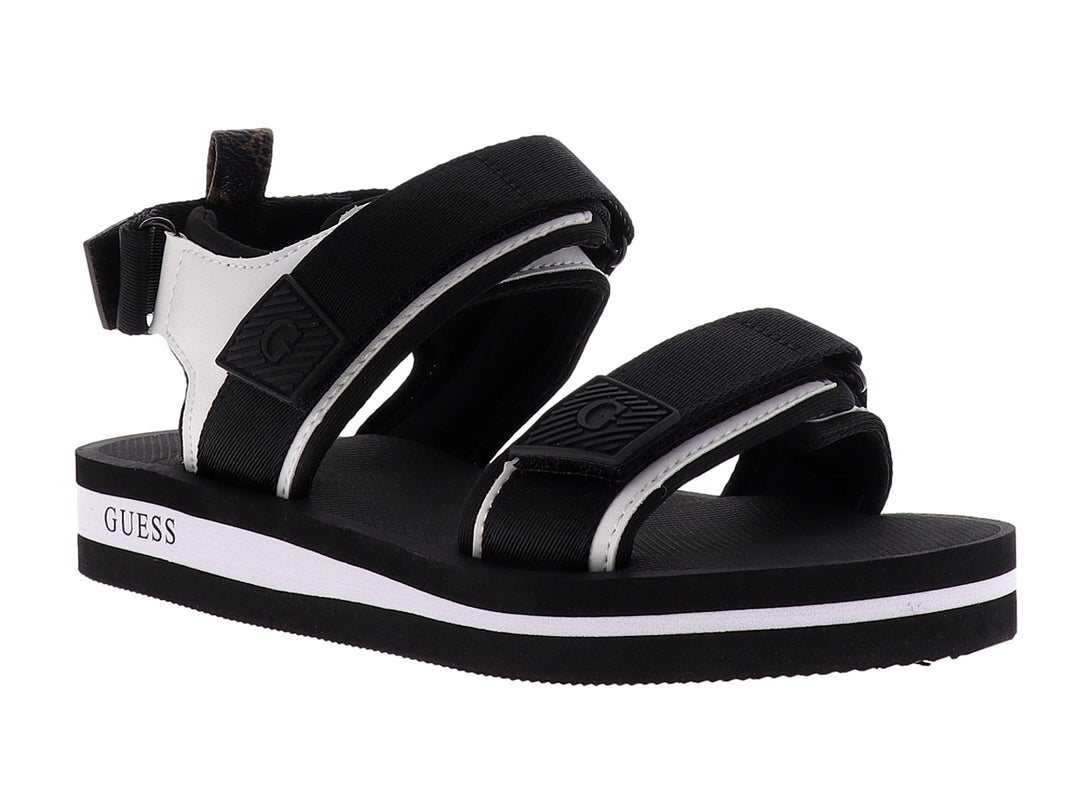 Sandalia gladiador Guess color negro y blanco con correas ajustables y suela plana.