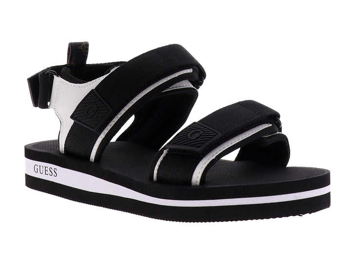 Sandalia gladiador Guess color negro y blanco con correas ajustables y suela plana.