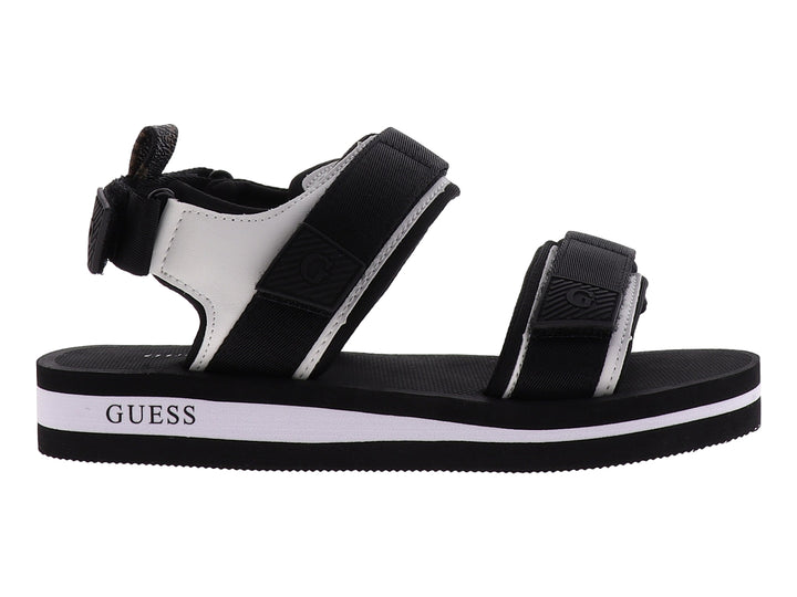 Sandalia gladiador Guess color negro y blanco con correas ajustables y suela plana.