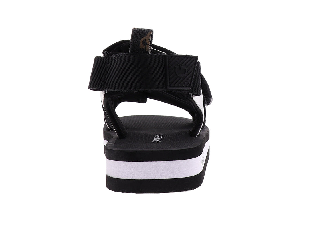 Sandalia gladiador Guess color negro y blanco con correas ajustables y suela plana.
