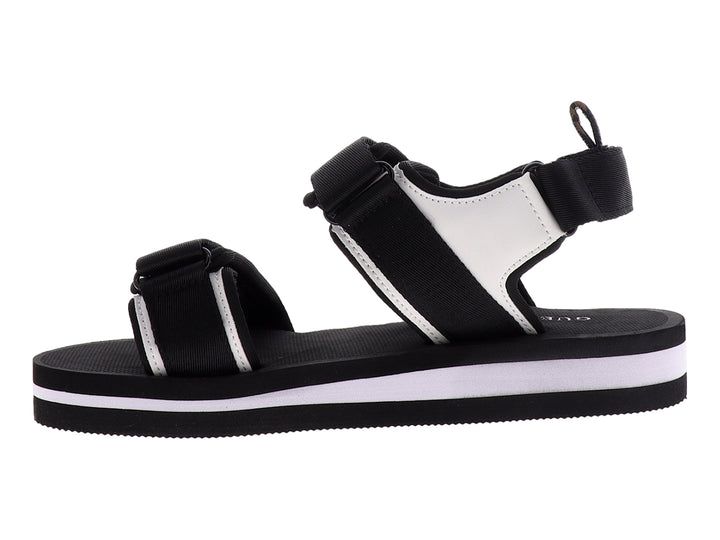 Sandalia gladiador Guess color negro y blanco con correas ajustables y suela plana.