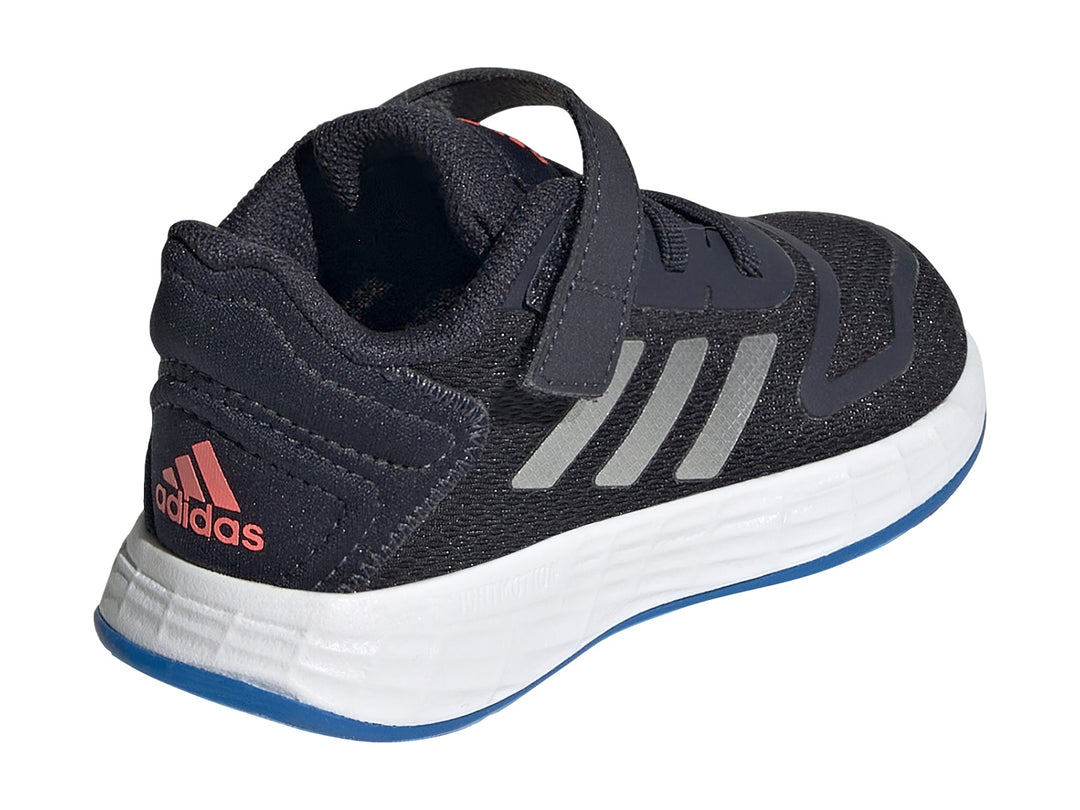 Tenis deportivos Adidas para niño en color azul marino con franjas plateadas y suela blanca.