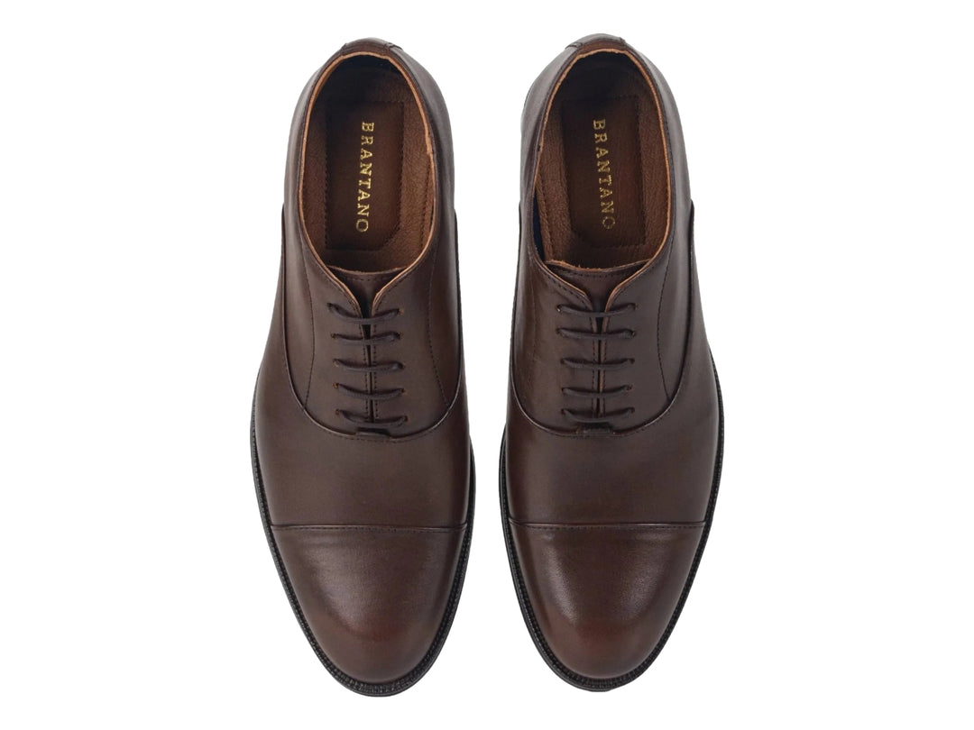 Zapato formal de cuero color café con agujetas y suela oscura.