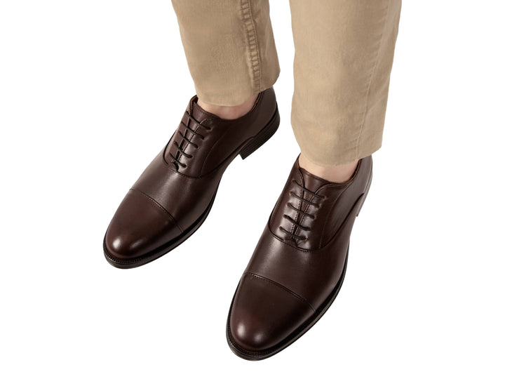 Zapato formal de cuero color café con agujetas y suela oscura.