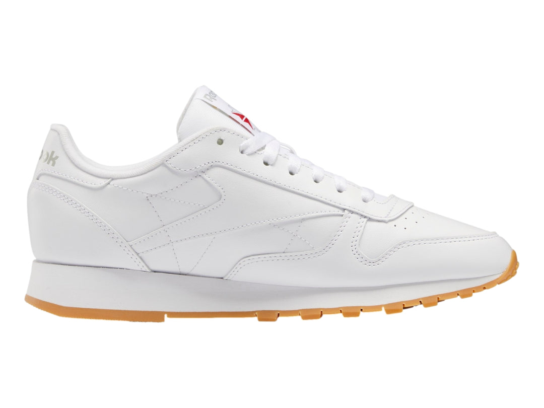Tenis Reebok Classic Leather color blanco con suela de goma color miel.