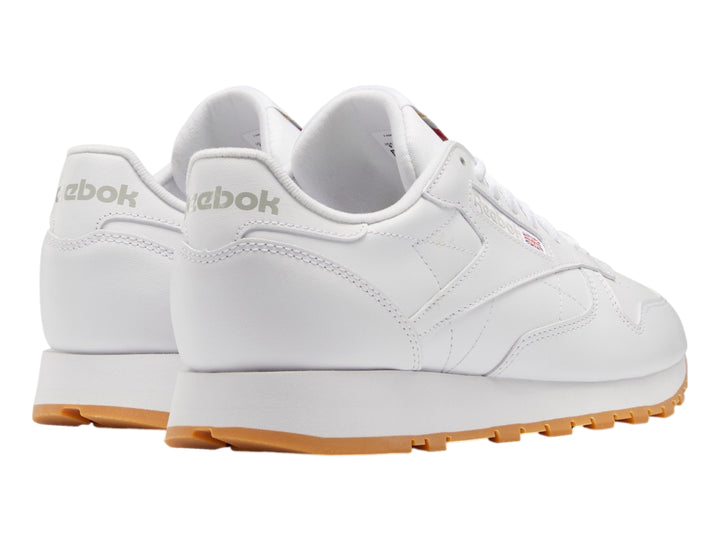 Tenis Reebok Classic Leather color blanco con suela de goma color miel.