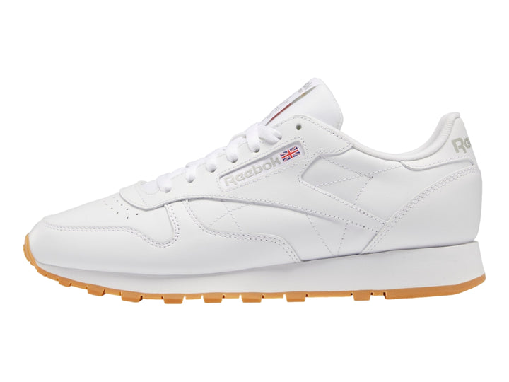 Tenis Reebok Classic Leather color blanco con suela de goma color miel.