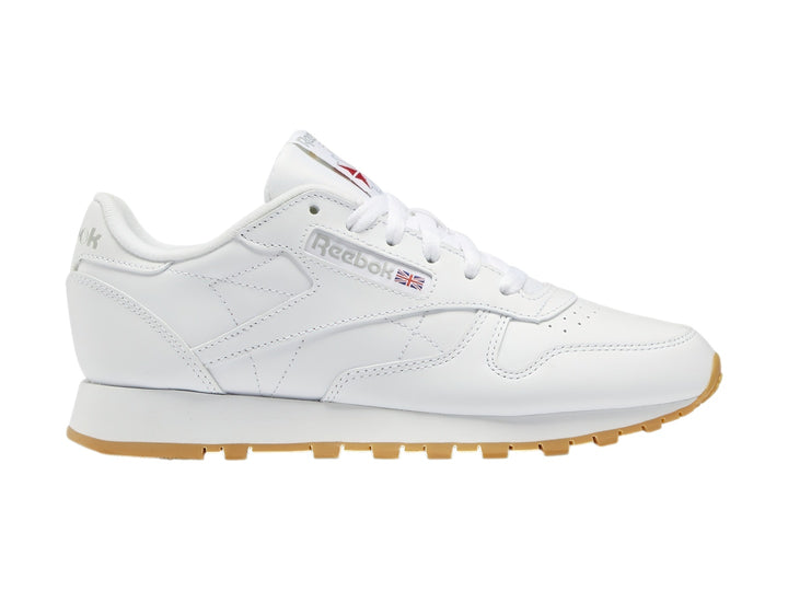 Tenis Reebok Classic Leather blancos con suela de goma color marrón.