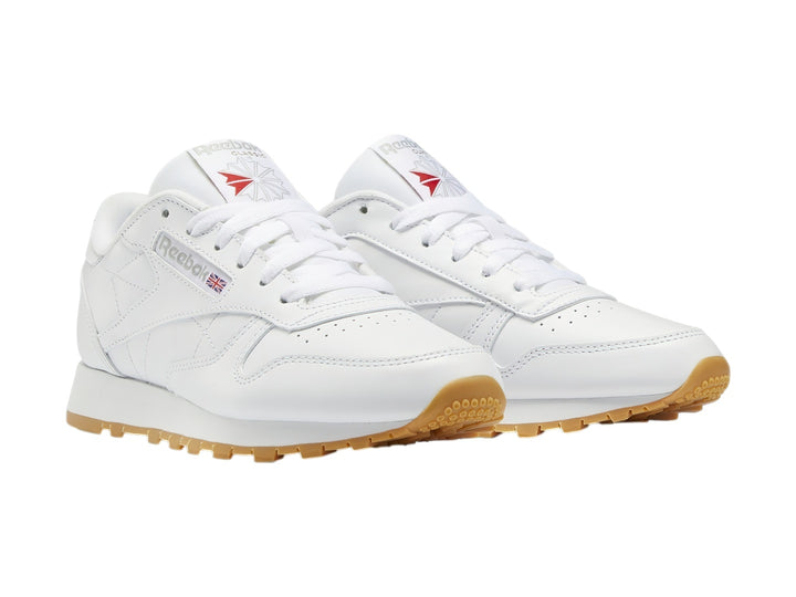 Tenis Reebok Classic Leather blancos con suela de goma color marrón.