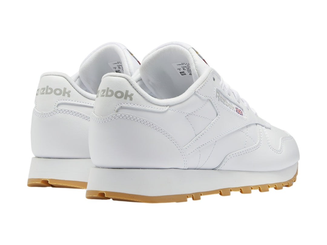 Tenis Reebok Classic Leather blancos con suela de goma color marrón.