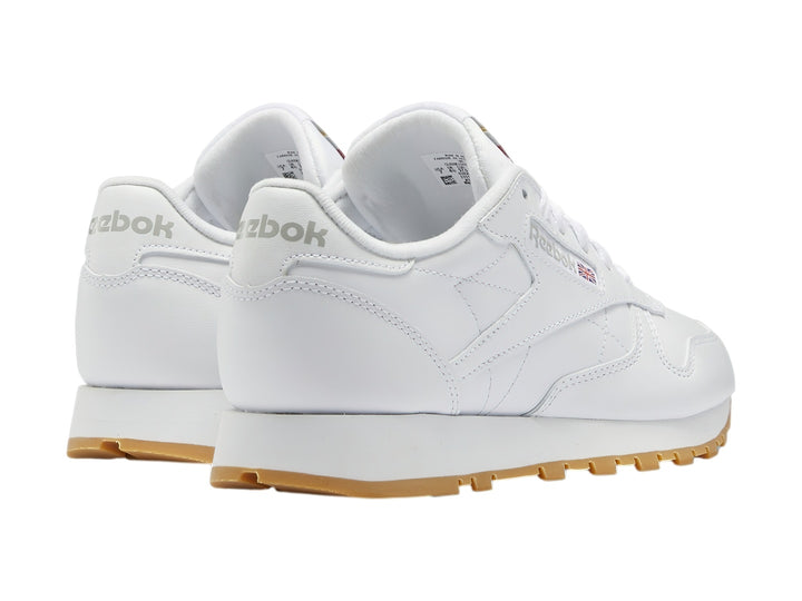 Tenis Reebok Classic Leather blancos con suela de goma color marrón.