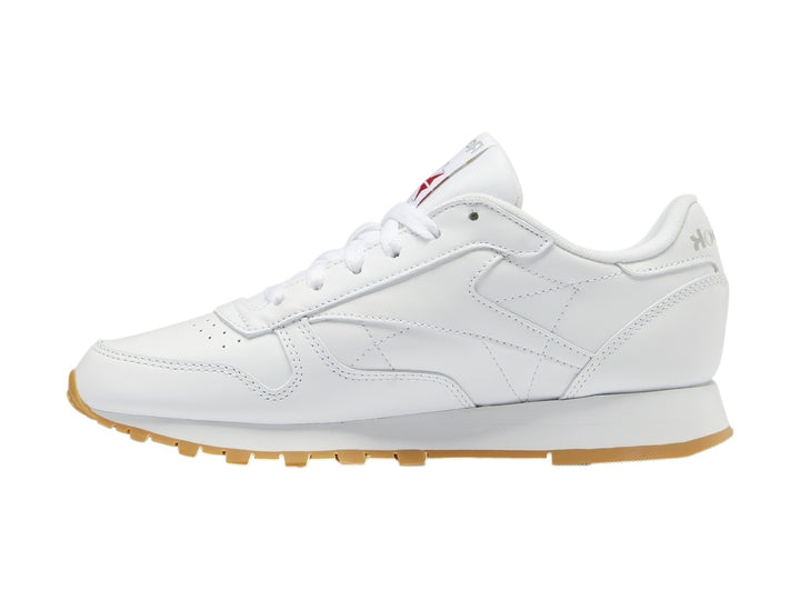 Tenis Reebok Classic Leather blancos con suela de goma color marrón.