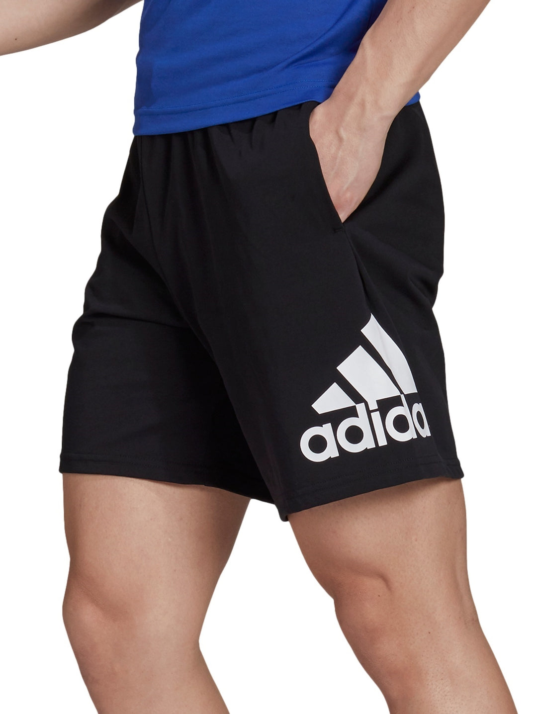 Hombre vistiendo shorts deportivos color negro de la marca Adidas.