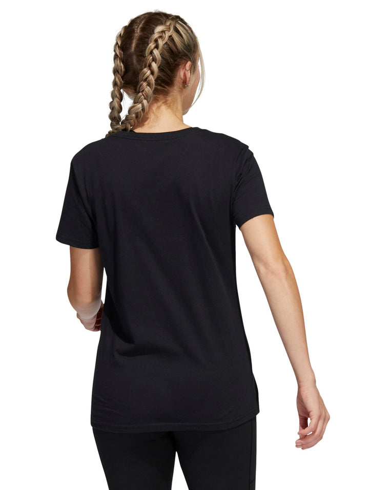 Mujer vistiendo playera deportiva Adidas color negro con logotipo lila en el pecho.