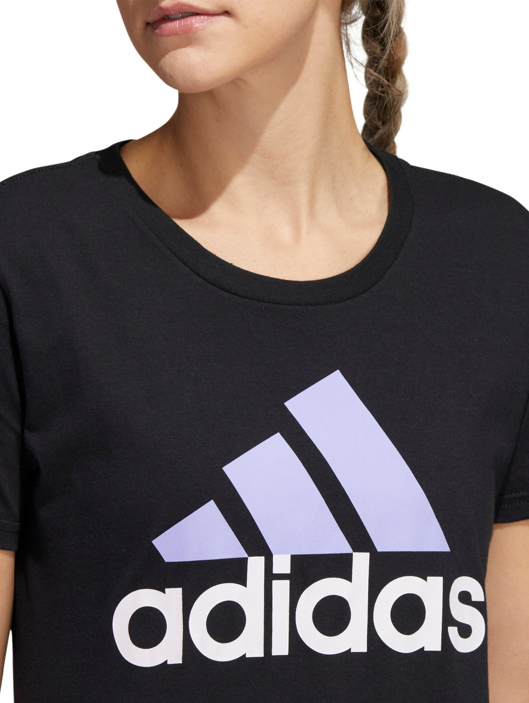 Mujer vistiendo playera deportiva Adidas color negro con logotipo lila en el pecho.