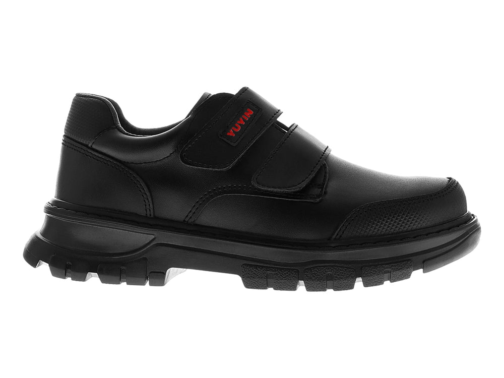 Zapato infantil color negro con cierre de velcro y suela gruesa.