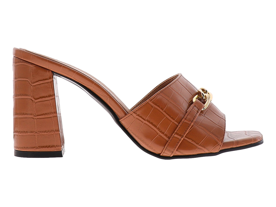 Sandalia mule color tan con tacón grueso, textura de cocodrilo y detalle de cadena dorada.