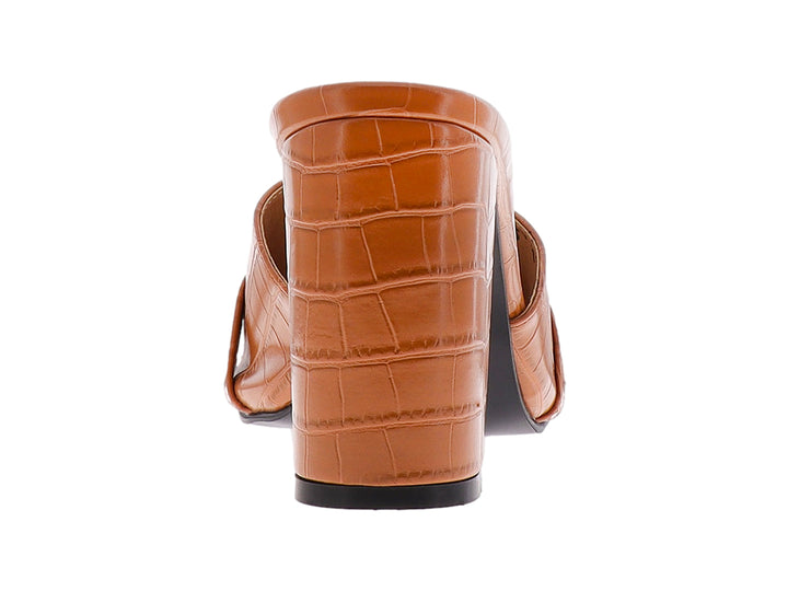 Sandalia mule color tan con tacón grueso, textura de cocodrilo y detalle de cadena dorada.