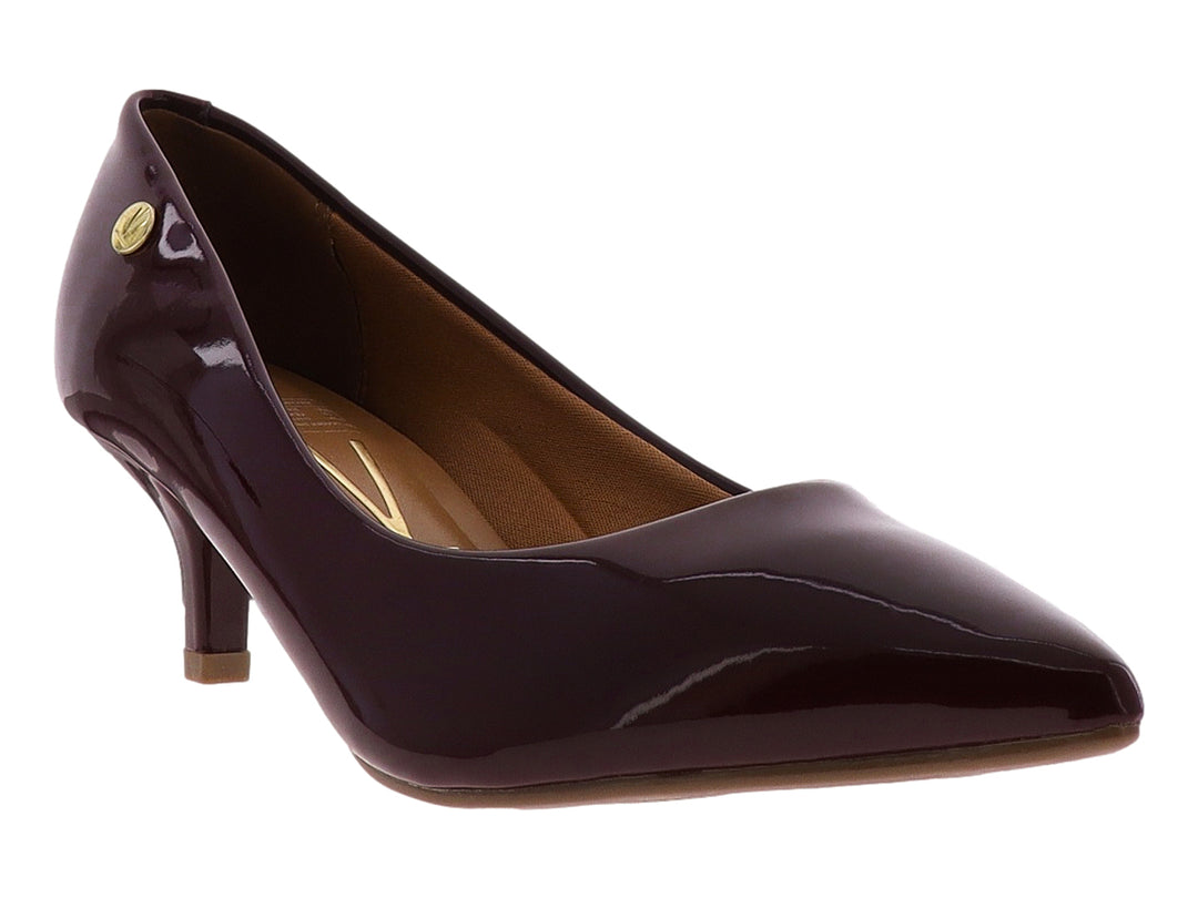 Zapato de tacón cerrado para mujer en color vino con acabado brillante tipo charol y punta fina.