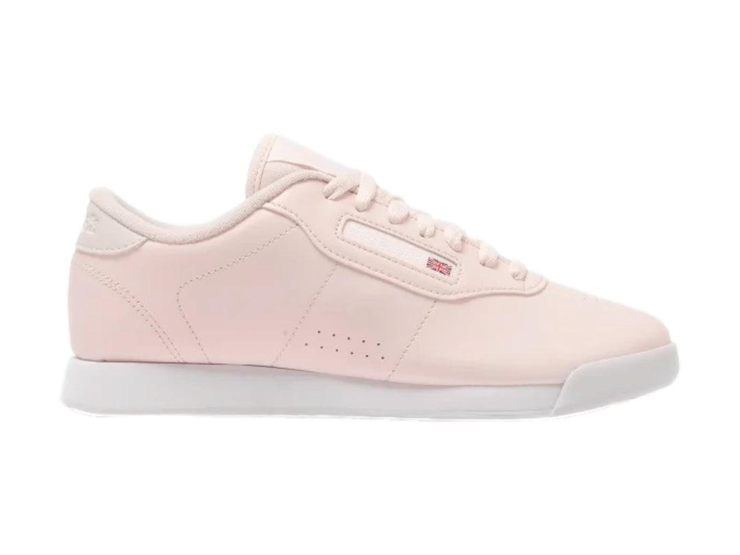 Tenis Reebok color rosa pastel con suela blanca y cordones.