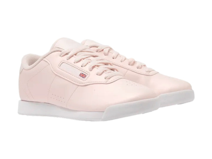 Tenis Reebok color rosa pastel con suela blanca y cordones.