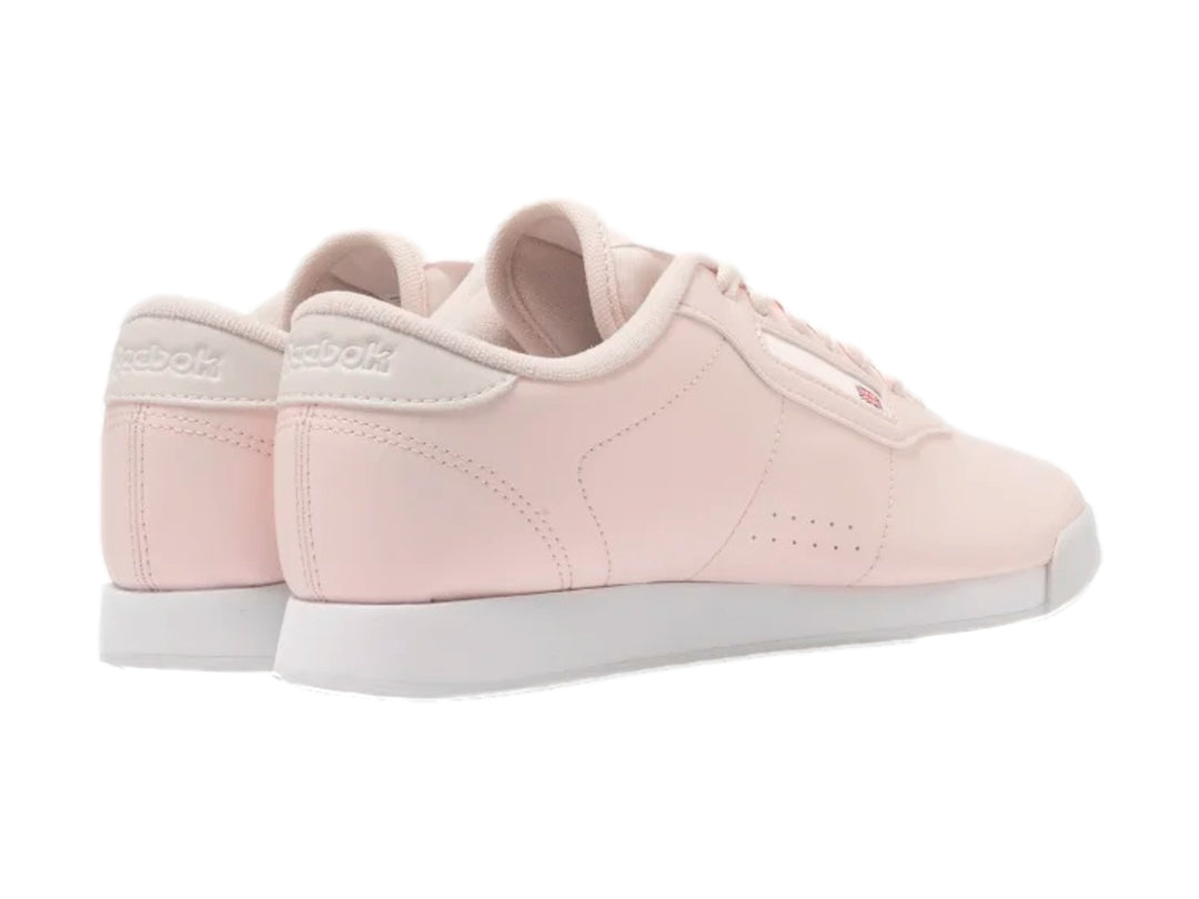 Tenis Reebok color rosa pastel con suela blanca y cordones.