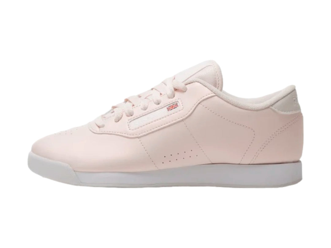 Tenis Reebok color rosa pastel con suela blanca y cordones.