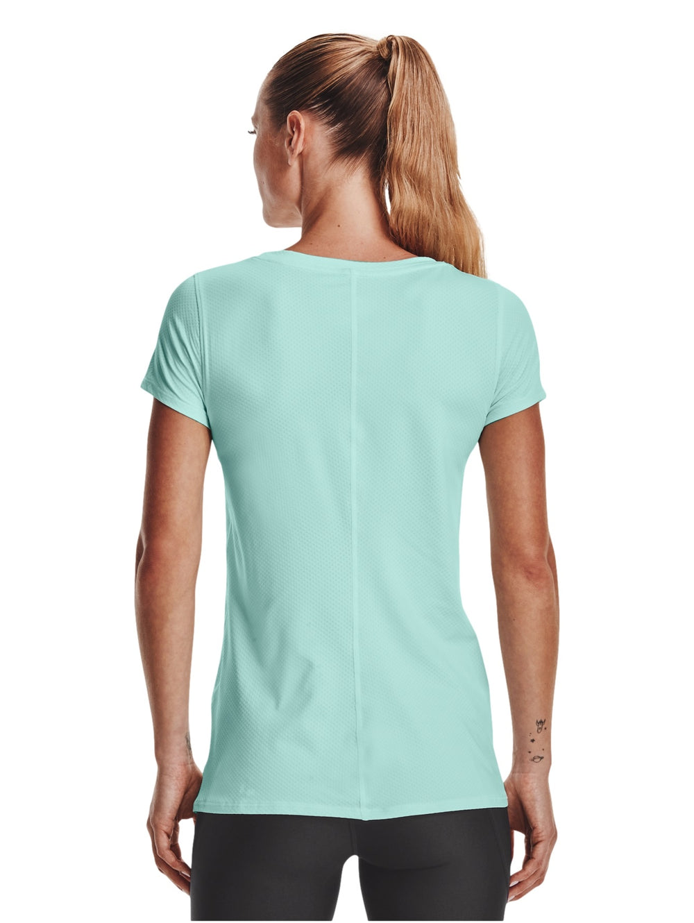 Mujer vistiendo una camiseta deportiva de manga corta color verde menta marca Under Armour.