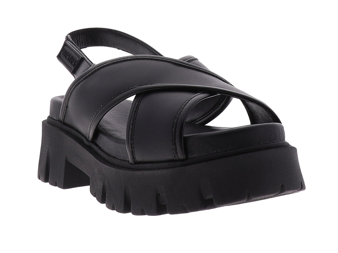 Sandalia negra de plataforma con correas cruzadas y suela gruesa dentada.