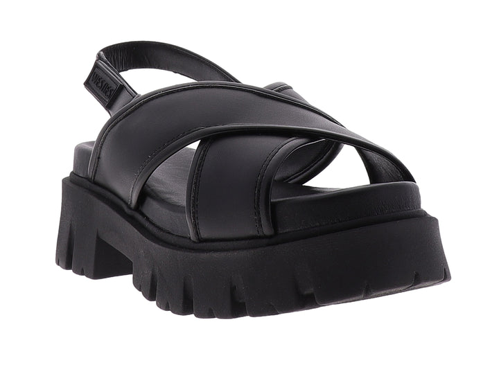 Sandalia negra de plataforma con correas cruzadas y suela gruesa dentada.