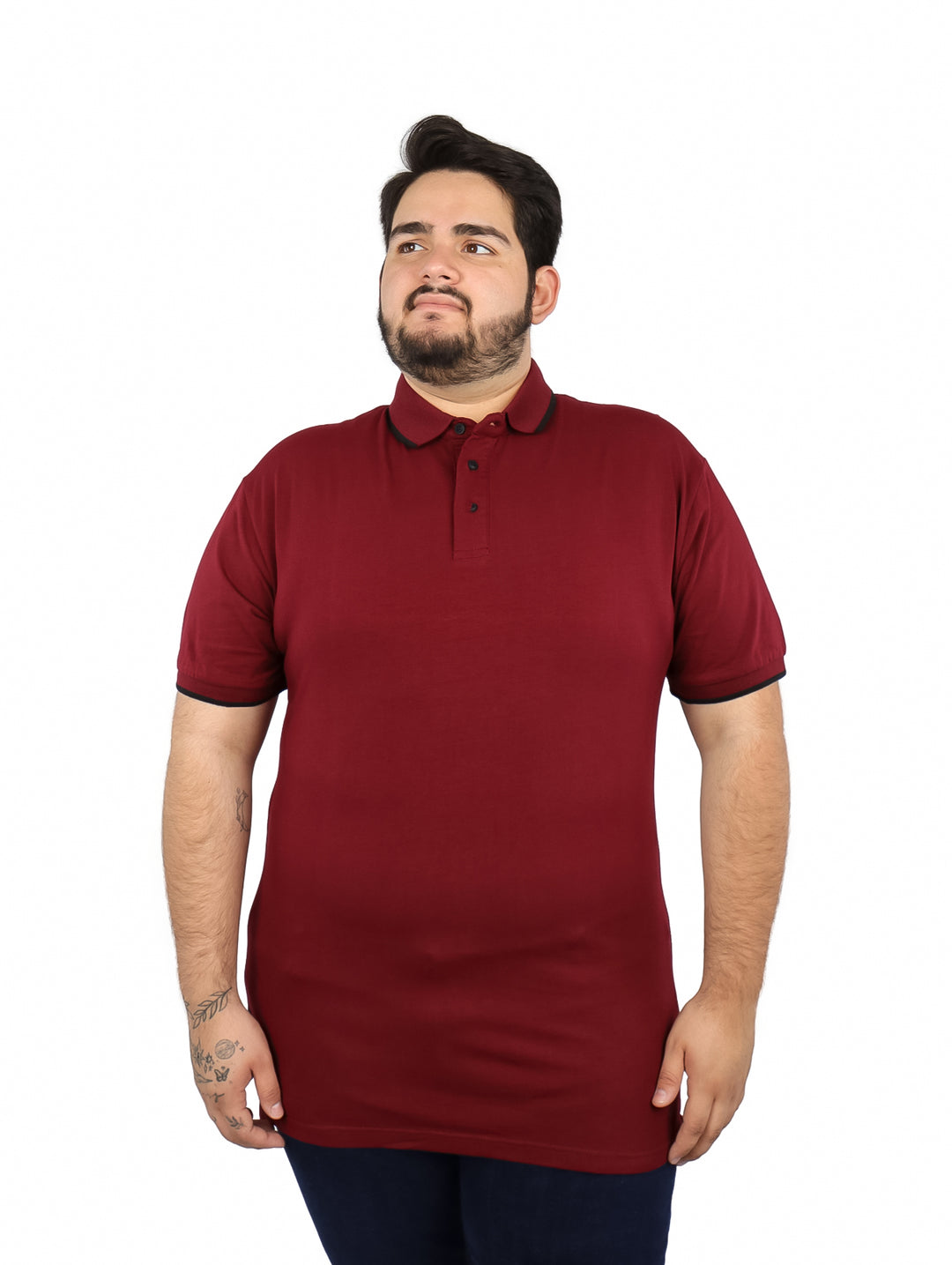 Hombre vistiendo una playera polo color vino con detalles negros en el cuello y mangas.