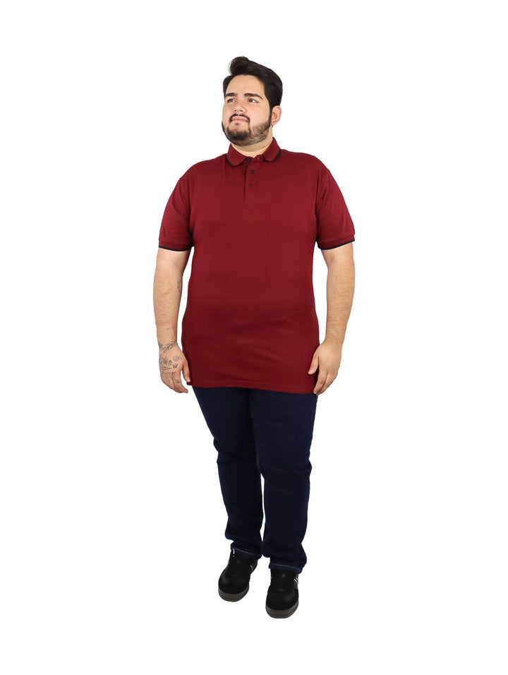 Hombre vistiendo una playera polo color vino con detalles negros en el cuello y mangas.