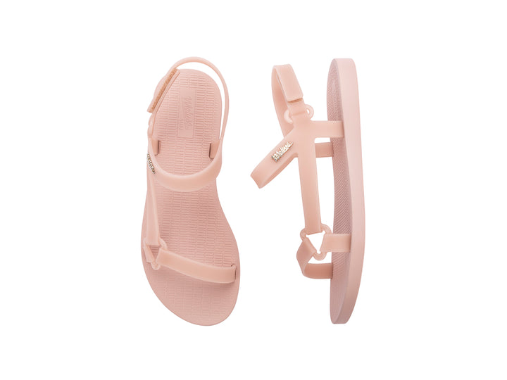 Par de sandalias Melissa color rosa oscuro con diseño de tiras y cierre en el tobillo sobre fondo blanco.