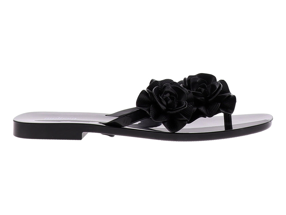 Sandalia de dedo color negro con adornos de rosas grandes y acabado brillante.