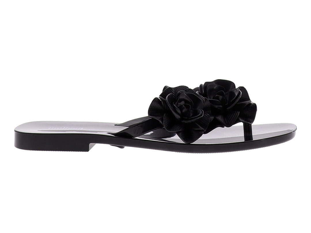 Sandalia de dedo color negro con adornos de rosas grandes y acabado brillante.