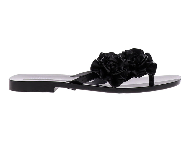 Sandalia de dedo color negro con adornos de rosas grandes y acabado brillante.