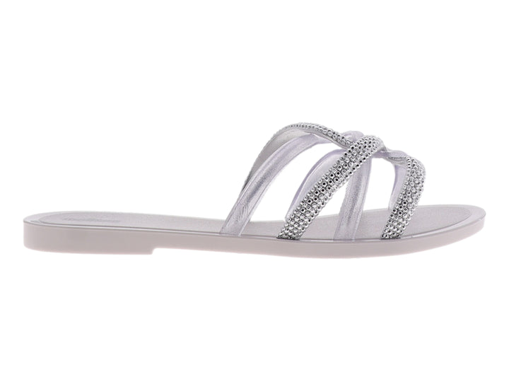 Sandalia Melissa blanca brillante con tiras cruzadas decoradas con cristales y suela plana.