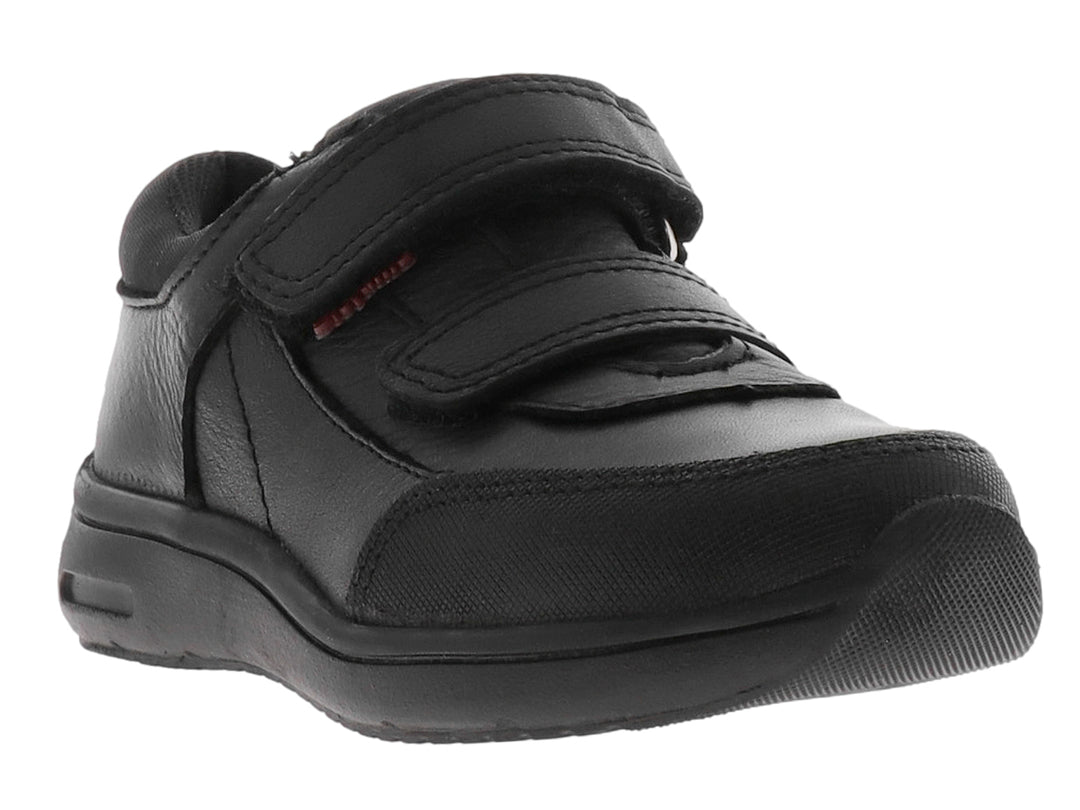 Zapato escolar negro para niño con cierre de velcro y suela gruesa.