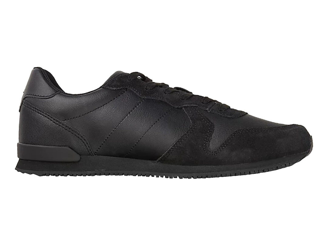 Tenis deportivos Tommy Hilfiger color negro confeccionados en cuero y gamuza con suela plana.
