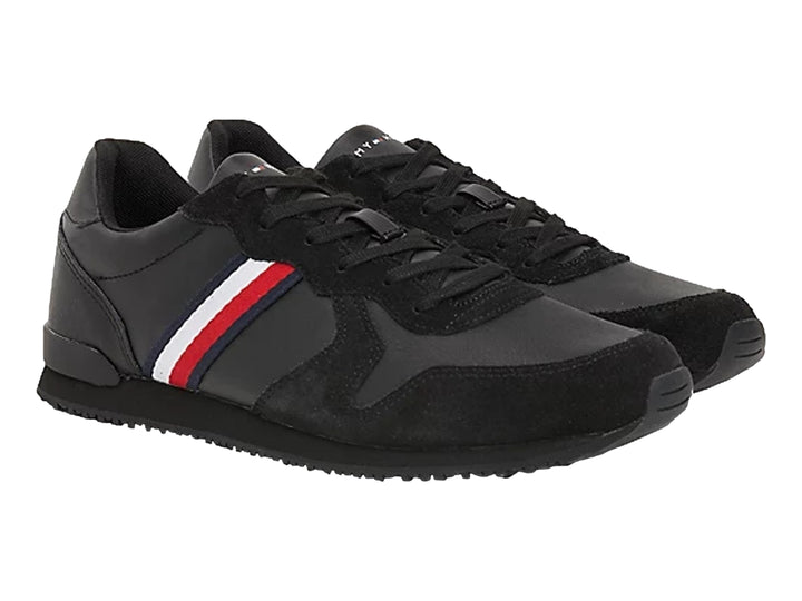 Tenis deportivos Tommy Hilfiger color negro confeccionados en cuero y gamuza con suela plana.