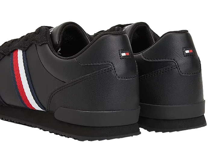 Tenis deportivos Tommy Hilfiger color negro confeccionados en cuero y gamuza con suela plana.