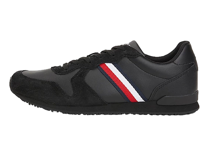 Tenis deportivos Tommy Hilfiger color negro confeccionados en cuero y gamuza con suela plana.
