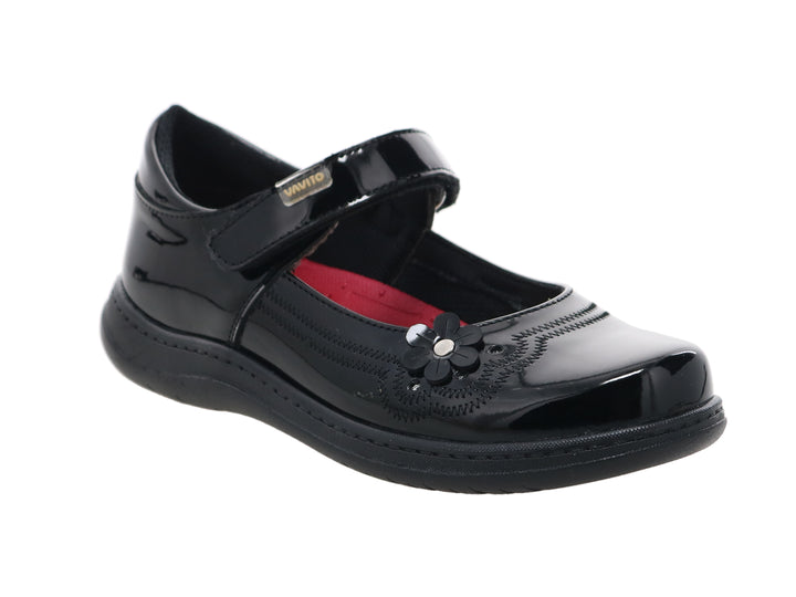 Zapato negro de charol para niña con detalle de flor y correa ajustable.