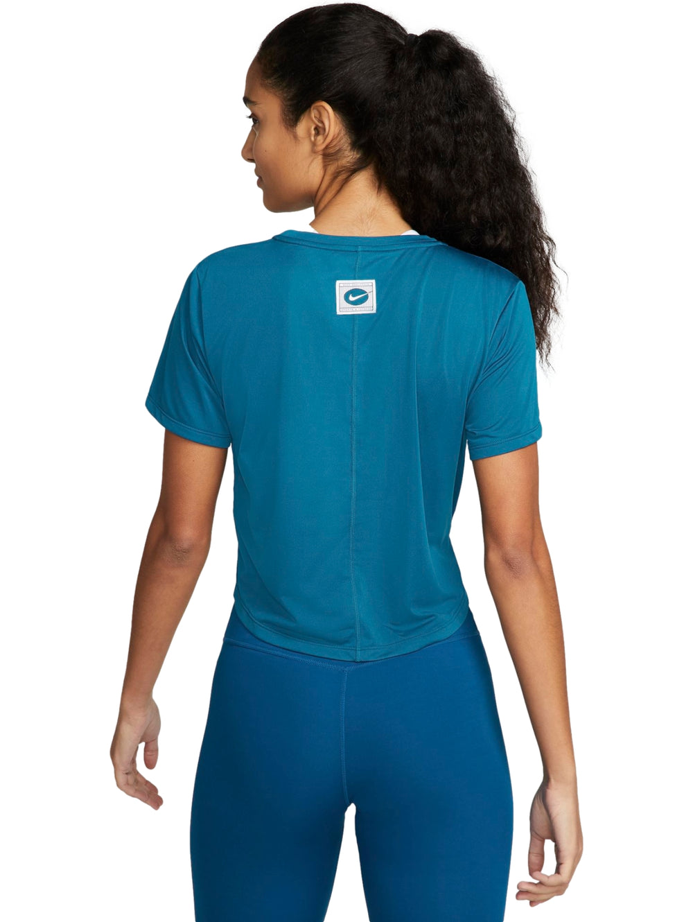 Mujer vistiendo una camiseta crop top de manga corta color azul marino de la marca Nike.