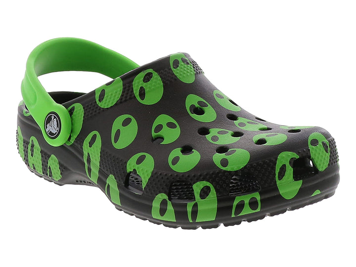 Zuecos Crocs negros con estampado de caras de alienígenas verdes y correa verde.