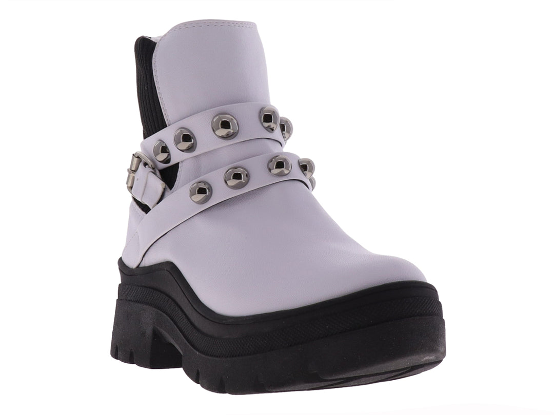 Bota blanca de cuero con suela gruesa negra y correas con estoperoles plateados.