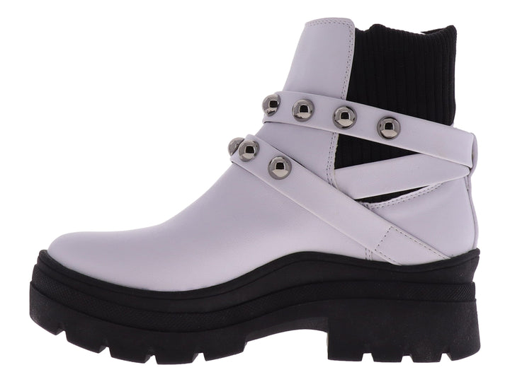 Bota blanca de cuero con suela gruesa negra y correas con estoperoles plateados.