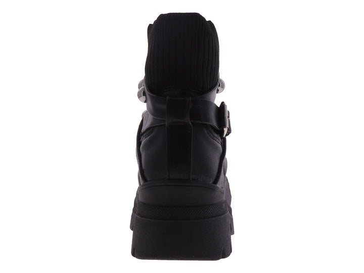 Bota negra de cuero con plataforma gruesa y correas decoradas con remaches plateados.